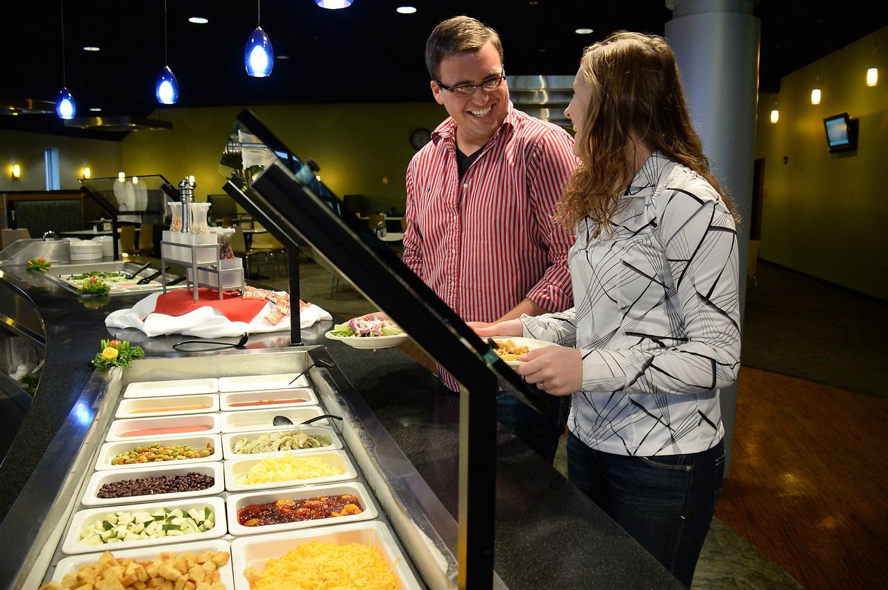 Two students talking to each other near the salad bar