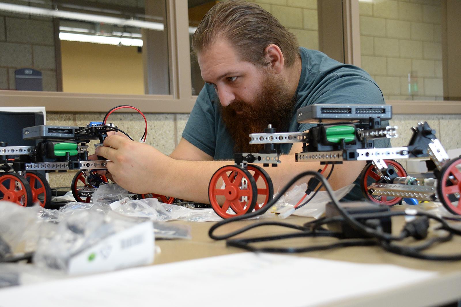 An engineering student putting together a remote controlled vehicle